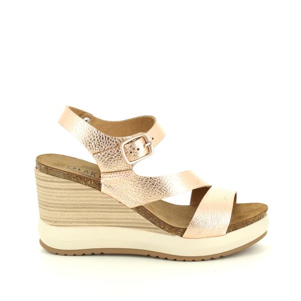A close-up photo showcasing Plakton's 375900 Gold Women's Wedge Sandals. The sandals feature a stylish multi-strap design in shimmering gold, with an adjustable ankle strap adorned with a buckle for a secure fit. The cork footbed provides comfort and support, while the wedge heel adds a touch of elegance. Made with premium vegan leather in Spain.